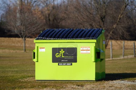 Téléchargez les photos : Waupun, Wisconsin États-Unis - novembre 23rd, 2022 : Green for Life écologiste benne à ordures se trouve à l'extérieur sur la campagne. - en image libre de droit