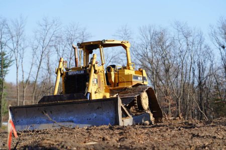Foto de Una gran excavadora se encuentra en una pila de un sitio de construcción en un día de verano en el bosque. - Imagen libre de derechos