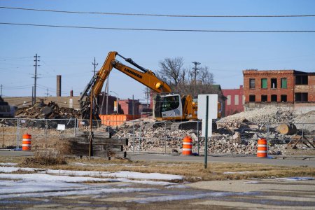 Photo for Racine, Wisconsin / USA - February 21st, 2020: Volvo, Liebherr, and Link-Belt excavators being used to demolishing an old building at a deconstruction site. - Royalty Free Image