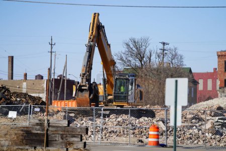 Photo for Racine, Wisconsin / USA - February 21st, 2020: Volvo, Liebherr, and Link-Belt excavators being used to demolishing an old building at a deconstruction site. - Royalty Free Image