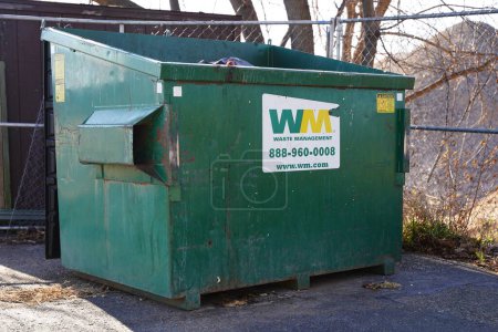Photo for Mauston, Wisconsin USA - November 23rd, 2020: Waste management green dumpster garbage bins sit outside to be used for the community - Royalty Free Image
