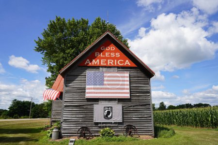 Téléchargez les photos : Green Lake, WIsconsin / États-Unis - 16 mai 2020 : Ancienne maison en bois abandonnée vintage située à la campagne de Green Lake, Wisconsin promouvant Dieu bénisse l'Amérique. - en image libre de droit