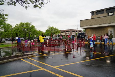 Téléchargez les photos : Fond du Lac, Wisconsin / États-Unis - 1er juin 2019 : Des membres de la communauté âgés, d "âge moyen et jeunes de Fond du Lac sont sortis par temps pluvieux mouillé pour s'amuser en famille au zoo pour enfants de la rue. - en image libre de droit