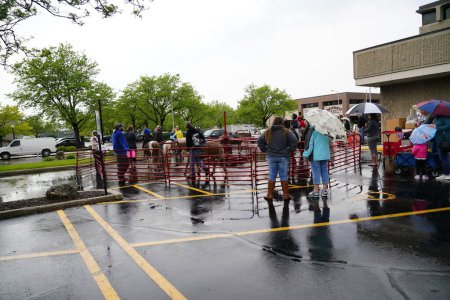 Photo for Fond du Lac, Wisconsin / USA - June 1st, 2019: Community old, middle-aged, and young members of Fond du Lac came out in the wet rainy weather to have some family fun at the street petting zoo. - Royalty Free Image