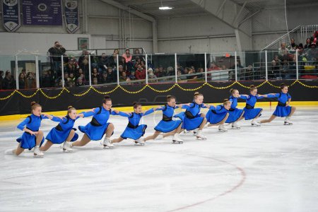 Photo for Mosinee, Wisconsin USA - February 26th, 2021: Young females in beautiful blue dresses synchronized skating together in the badger state winter games ice skating competition. - Royalty Free Image