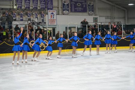 Téléchargez les photos : Mosinee, Wisconsin États-Unis - 26 février 2021 : Jeunes femmes en belles robes bleues synchronisées patinant ensemble dans la compétition de patinage sur glace des jeux d'hiver de l'État du blaireau. - en image libre de droit