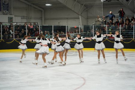 Téléchargez les photos : Mosinee, Wisconsin États-Unis - 26 février 2021 : Jeunes femmes en belles robes blanches synchronisées patinant ensemble dans la compétition de patinage sur glace des jeux d'hiver de l'État du blaireau. - en image libre de droit