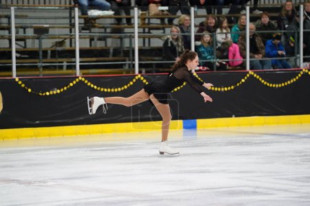 Photo for Mosinee, Wisconsin USA - February 26th, 2021: Young teenager female in a beautiful black dress participated in badger state winter games ice skating competition - Royalty Free Image