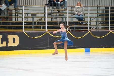 Téléchargez les photos : Mosinee, Wisconsin États-Unis - 26 février 2021 : Une jeune femme adulte dans une belle robe bleue a participé à la compétition de patinage sur glace des jeux d'hiver de l'État du blaireau - en image libre de droit