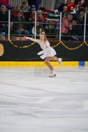 Téléchargez les photos : Mosinee, Wisconsin États-Unis - 26 février 2021 : Une jeune femme adulte dans une belle robe blanche a participé à la compétition de patinage sur glace des jeux d'hiver de l'État du blaireau. - en image libre de droit