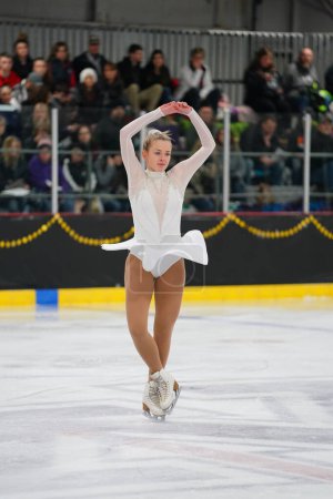 Foto de Mosinee, Wisconsin, EE.UU. - 26 de febrero de 2021: Mujer adulta joven con un hermoso vestido blanco participó en la competencia de patinaje sobre hielo de los juegos de invierno de Badger State.. - Imagen libre de derechos