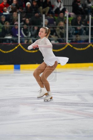 Photo for Mosinee, Wisconsin USA - February 26th, 2021: Young adult female in a beautiful white dress participated in badger state winter games ice skating competition. - Royalty Free Image