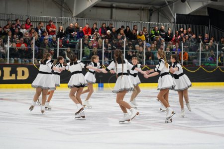 Téléchargez les photos : Mosinee, Wisconsin États-Unis - 26 février 2021 : Jeunes femmes en belles robes blanches synchronisées patinant ensemble dans la compétition de patinage sur glace des jeux d'hiver de l'État du blaireau. - en image libre de droit