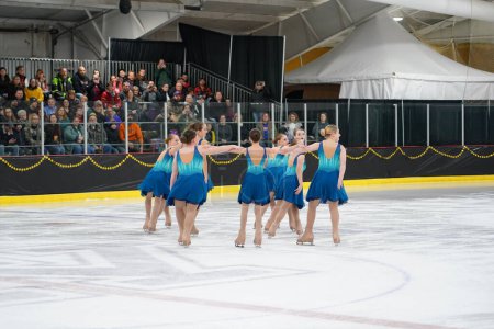 Photo for Mosinee, Wisconsin USA - February 26th, 2021: Young females in beautiful blue dresses figure skating together in the badger state winter games ice skating competition - Royalty Free Image