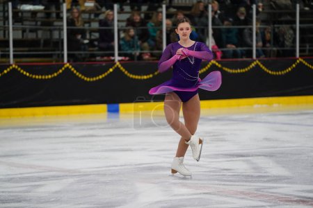 Téléchargez les photos : Mosinee, Wisconsin États-Unis - février 26th, 2021 : Jeune adolescente caucasienne dans une belle robe violette a participé à la compétition de patinage sur glace des jeux d'hiver de l'État du blaireau - en image libre de droit