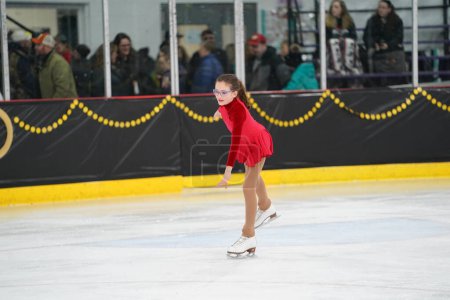 Téléchargez les photos : Mosinee, Wisconsin États-Unis - 26 février 2021 : Une jeune femme adulte dans une belle robe rouge a participé à la compétition de patinage sur glace des jeux d'hiver de l'État du blaireau - en image libre de droit