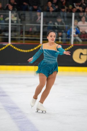 Photo for Mosinee, Wisconsin USA - February 26th, 2021: Adult female in a beautiful turquoise dress participated in badger state winter games ice skating competition - Royalty Free Image