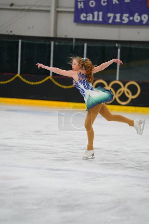 Téléchargez les photos : Mosinee, Wisconsin États-Unis - 26 février 2021 : Femme adulte dans une belle robe blanche a participé à la compétition de patinage sur glace des jeux d'hiver de l'État du blaireau - en image libre de droit