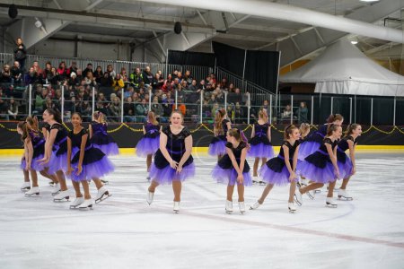 Téléchargez les photos : Mosinee, Wisconsin États-Unis - 26 février 2021 : Jeunes femmes en belles robes violettes synchronisées patinant ensemble dans la compétition de patinage sur glace des jeux d'hiver de l'État du blaireau. - en image libre de droit