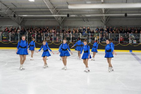 Foto de Mosinee, Wisconsin, Estados Unidos - 26 de febrero de 2021: Mujeres jóvenes en hermosos vestidos azules patinando juntas en la competencia de patinaje sobre hielo de los juegos de invierno de Badger State - Imagen libre de derechos
