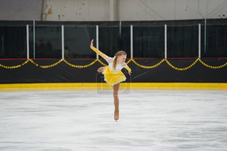 Téléchargez les photos : Mosinee, Wisconsin États-Unis - 26 février 2021 : Femme adulte dans une belle robe jaune a participé à la compétition de patinage sur glace des jeux d'hiver de l'État du blaireau - en image libre de droit