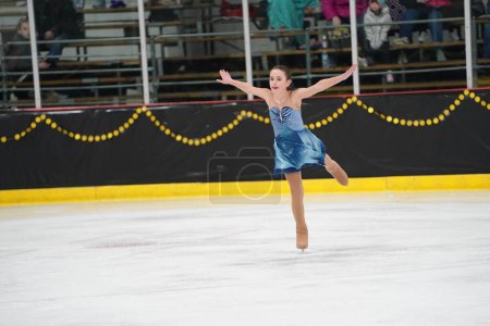 Téléchargez les photos : Mosinee, Wisconsin États-Unis - 26 février 2021 : Une jeune femme adulte dans une belle robe bleue a participé à la compétition de patinage sur glace des jeux d'hiver de l'État du blaireau. - en image libre de droit