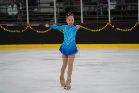 Téléchargez les photos : Mosinee, Wisconsin États-Unis - février 26th, 2021 : Jeune femme asiatique dans une belle robe bleue a participé à la compétition de patinage sur glace des jeux d'hiver de l'État du blaireau. - en image libre de droit
