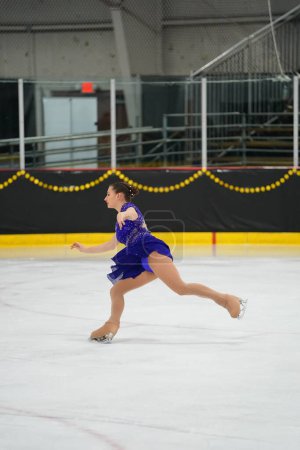 Foto de Mosinee, Wisconsin, EE.UU. - 26 de febrero de 2021: Mujer adulta joven con un hermoso vestido azul participó en la competencia de patinaje sobre hielo de los juegos de invierno de Badger State.. - Imagen libre de derechos