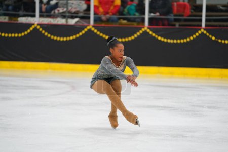 Téléchargez les photos : Mosinee, Wisconsin États-Unis - 26 février 2021 : Femme afro-américaine adulte dans une belle robe grise a participé à la compétition de patinage sur glace des jeux d'hiver de l'État du blaireau - en image libre de droit