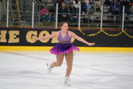 Photo for Mosinee, Wisconsin USA - February 26th, 2021: Young adult female in a beautiful purple dress participated in badger state winter games ice skating competition - Royalty Free Image