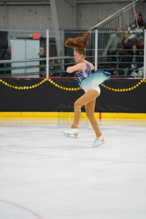 Foto de Mosinee, Wisconsin, EE.UU. - 26 de febrero de 2021: Mujer adulta con un hermoso vestido blanco participó en la competencia de patinaje sobre hielo de los juegos de invierno de Badger State. - Imagen libre de derechos