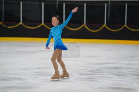 Téléchargez les photos : Mosinee, Wisconsin États-Unis - février 26th, 2021 : Jeune femme asiatique dans une belle robe bleue a participé à la compétition de patinage sur glace des jeux d'hiver de l'État du blaireau. - en image libre de droit