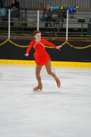 Téléchargez les photos : Mosinee, Wisconsin États-Unis - 26 février 2021 : Une jeune femme adulte dans une belle robe rouge a participé à la compétition de patinage sur glace des jeux d'hiver de l'État du blaireau - en image libre de droit