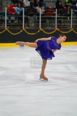 Photo for Mosinee, Wisconsin USA - February 26th, 2021: Young adult female in a beautiful blue dress participated in badger state winter games ice skating competition. - Royalty Free Image
