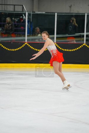 Foto de Mosinee, Wisconsin, EE.UU. - 26 de febrero de 2021: Una joven adulta con un hermoso vestido colorido participó en la competencia de patinaje sobre hielo de los juegos de invierno de Badger State. - Imagen libre de derechos