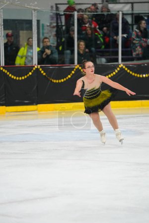 Foto de Mosinee, Wisconsin, Estados Unidos - 26 de febrero de 2021: Una joven adolescente con un hermoso vestido negro participó en la competencia de patinaje sobre hielo de los juegos de invierno de Badger State. - Imagen libre de derechos