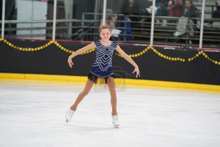Téléchargez les photos : Mosinee, Wisconsin États-Unis - 26 février 2021 : Une jeune femme adulte dans une belle robe bleue a participé à la compétition de patinage sur glace des jeux d'hiver de l'État du blaireau. - en image libre de droit