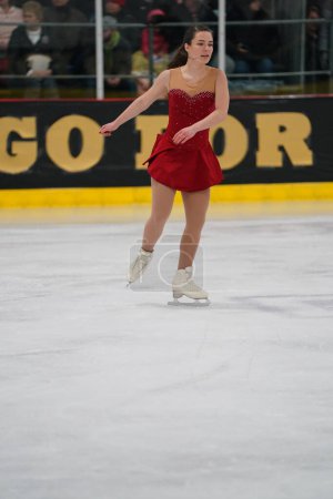 Foto de Mosinee, Wisconsin, EE.UU. - 26 de febrero de 2021: Mujer adulta joven con un hermoso vestido rojo participó en la competencia de patinaje sobre hielo de los juegos de invierno de Badger State.. - Imagen libre de derechos