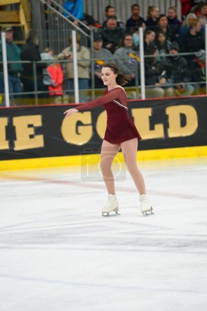 Foto de Mosinee, Wisconsin, EE.UU. - 26 de febrero de 2021: Mujer adulta joven con un hermoso vestido rojo participó en la competencia de patinaje sobre hielo de los juegos de invierno de Badger State.. - Imagen libre de derechos
