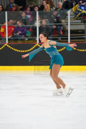 Téléchargez les photos : Mosinee, Wisconsin États-Unis - 26 février 2021 : Femme adulte dans une belle robe turquoise a participé à la compétition de patinage sur glace des jeux d'hiver de l'État du blaireau - en image libre de droit
