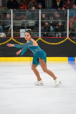 Photo for Mosinee, Wisconsin USA - February 26th, 2021: Adult female in a beautiful turquoise dress participated in badger state winter games ice skating competition - Royalty Free Image