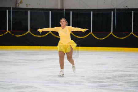 Foto de Mosinee, Wisconsin, EE.UU. - 26 de febrero de 2021: Una joven adulta con un hermoso vestido amarillo participó en la competencia de patinaje sobre hielo de los juegos de invierno de Badger State. - Imagen libre de derechos
