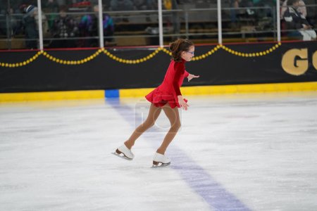 Photo for Mosinee, Wisconsin USA - February 26th, 2021: Young female in a beautiful red dress participated in badger state winter games ice skating competition - Royalty Free Image