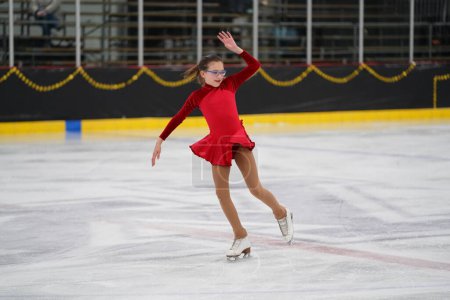 Foto de Mosinee, Wisconsin, EE.UU. - 26 de febrero de 2021: Mujer adulta con un hermoso vestido rojo participó en la competencia de patinaje sobre hielo de los juegos de invierno de Badger State. - Imagen libre de derechos