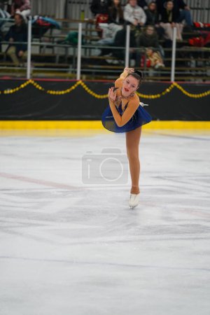 Photo for Mosinee, Wisconsin USA - February 26th, 2021: Adult female in a beautiful blue dress participated in badger state winter games ice skating competition - Royalty Free Image