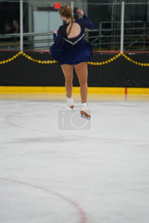 Foto de Mosinee, Wisconsin, EE.UU. - 26 de febrero de 2021: Mujer adulta joven con un hermoso vestido azul participó en la competencia de patinaje sobre hielo de los juegos de invierno de Badger State. - Imagen libre de derechos