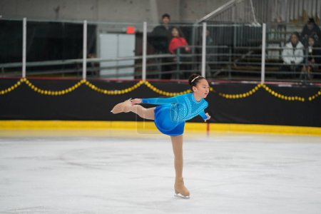 Téléchargez les photos : Mosinee, Wisconsin États-Unis - février 26th, 2021 : Jeune femme asiatique dans une belle robe bleue a participé à la compétition de patinage sur glace des jeux d'hiver de l'État du blaireau - en image libre de droit