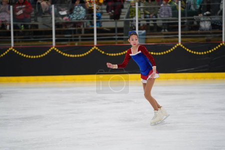 Photo for Mosinee, Wisconsin USA - February 26th, 2021: Young adult female in a beautiful blue dress participated in badger state winter games ice skating competition - Royalty Free Image