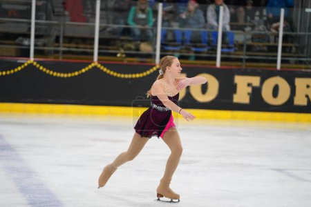 Foto de Mosinee, Wisconsin, EE.UU. - 26 de febrero de 2021: Mujer adulta con un hermoso vestido morado participó en la competencia de patinaje sobre hielo de los juegos de invierno de Badger State. - Imagen libre de derechos