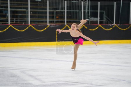 Foto de Mosinee, Wisconsin, EE.UU. - 26 de febrero de 2021: Joven adolescente caucásica con un hermoso vestido morado participó en la competencia de patinaje sobre hielo de los juegos de invierno de Badger State. - Imagen libre de derechos